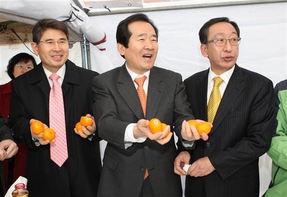정세균 민주당 대표(가운데)가 4일 제주도 혁신도시 현장을 둘러본 뒤 환담하며 감귤을 먹다 취재기자들에게도 먹어보라고 권하고 있다. 왼쪽은 김재윤 의원, 오른쪽은 고희범 민주당 제주도지사 예비후보. 제주/연합뉴스