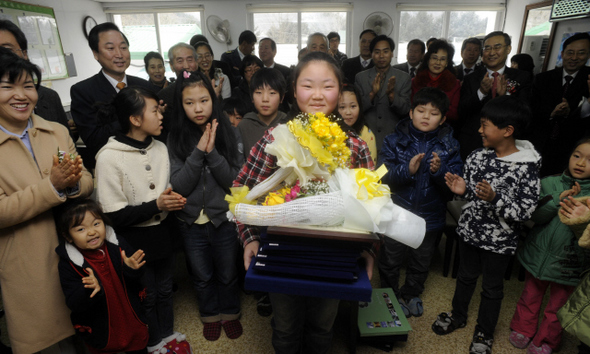  16일 오전에 열린 강원 춘천시 북산면 추곡초등학교 제45회 졸업식에서 유일한 졸업생인 김진영(13)양이 10여 개가 넘는 상장과 장학증서를 받아들고 후배들과 선생님, 학부모들의 축하를 받고 있다. 신북면에는 애초 11개가 넘는 초등학교가 있었으나, 소양댐 건설로 수몰돼 육지속의 섬으로 변한 뒤 추곡초등학교만 남았다. 새학기에는 이농과 인구 감소로 입학생이 없다.  춘천/강재훈 선임기자 khan@hani.co.kr