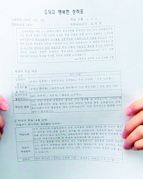 중랑중학교 김태훈 교사가 17일 오전 교실에서 학생들과 함께 하고 있다. 학생들이 들고 있는 것은 기존 성적표 대신 김교사가 직접 만든 행복성적표. 박종식 기자 anaki@hani.co.kr