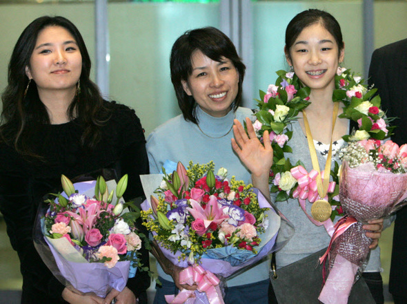  김연아(오른쪽)가 2006년 11월 열린 시니어 그랑프리 대회에서 처음 우승한 뒤 어머니 박미희(가운데)씨와 함께 인천공항으로 입국해 시민들의 환영을 받고 있다. 왼쪽은 박분선 코치. 연합뉴스