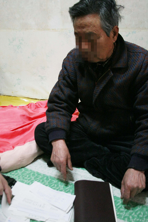 여중생 납치살해 피의자 김길태의 아버지 김모 씨가 김길태 교도소 수감 중 자신이 보낸 영치금 영수증을 내려다보고 있다. 연합뉴스