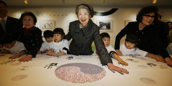 <b>안 의사 100주기 기념우표 발행</b> 미국에 살고 있는 안중근 의사의 손녀 안연호(가운데)씨가 안 의사 순국 100주기를 맞아 방한해 22일 오전 서울 충무로1가 서울중앙우체국에서 안 의사 외손녀와 이곳을 찾은 어린이들과 함께 대형 기념우표에 손도장을 찍고 있다. 왼쪽부터 안 의사의 외손녀 황은주(안경 쓴 이)씨, 안연호씨, 외손녀 황은실씨.  박종식 기자 anaki@hani.co.kr
