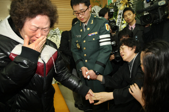 <b>눈물만 흘러내렸다</b> 천안함이 침몰한 뒤 실종된 승조원의 한 가족(왼쪽)이 31일 오전 경기도 성남 국군수도병원에 마련된 한주호 준위의 빈소를 찾아 그의 부인 김말순씨(오른쪽 둘째)와 아들 한상기 중위(오른쪽 셋째)에게 조의를 표하다 함께 울고 있다. 한 준위는 30일 천안함 침몰 해역에서 수중 수색작업을 벌이다 순직했다.  성남/연합뉴스