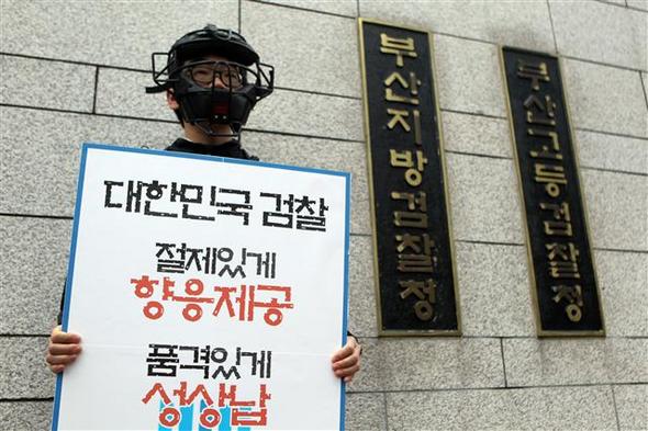 부산 지역 건설업체 전 대표인 정아무개씨가 부산지검 등 검찰 간부와 검사들에게 향응과 성접대를 제공했다고 폭로해 파문이 확산된 21일 부산지검 앞에서 한 대학생이 검찰을 비판하는 1인시위를 하고 있다. 부산/연합뉴스