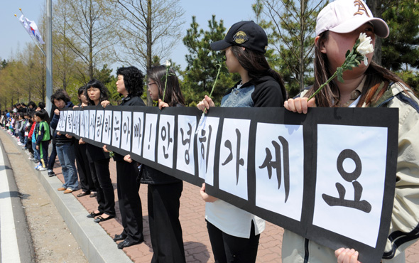 희생 장병들이 살았던 평택 포승읍 해군아파트 주민들이 손에 국화를 든 채 단지 앞 도로에서 장병들의 마지막 가는 길을 배웅하고 있다. 평택 대전/사진공동취재단