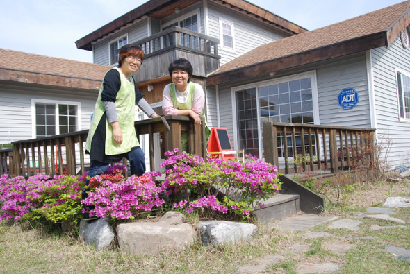  ‘햇살 아이마을’을 함께 개원한 문서경 대표(오른쪽)와 박금순씨가 실내에서 작업을 하다가 어린이집 앞에서 잠시 쉬며 즐거워하고 있다.