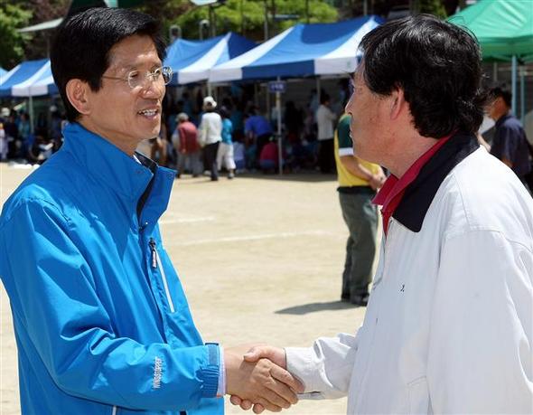 김문수 한나라당 경기지사 후보(왼쪽)가 16일 경기 광주시의 한 중학교를 찾아 주민과 악수하며 지지를 호소하고 있다.  경기 광주/연합뉴스