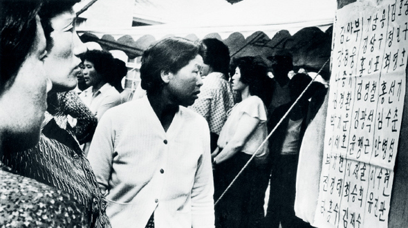 1980년 5월21일 계엄군이 물러난 이후 전남도청 항쟁지도부에서는 행방불명자의 명단을 접수해 각 병원의 사상자 명단과 대조해 게시했다. 23일 도청 앞에서 가족을 찾아 나선 여성들이 명단을 확인하고 있다.  <광주는 말한다> 신복진 사진집에서