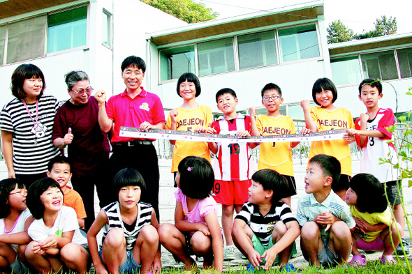 아리랑 응원단장 박용식씨(뒷줄 왼쪽에서 셋째)가 2008년 대전 성우보육원 아이들과 맨체스터 유나이티드 내한 경기 입장권을 들고 즐거워하고 있다. 송인걸 기자