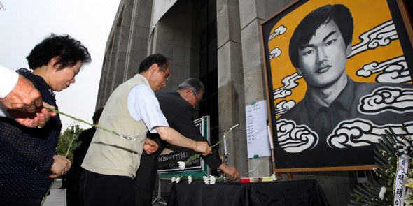 이한열 열사 23주기 추모제가 9일 낮 서울 서대문구 신촌동 연세대 도서관 앞에서 열려, 참석자들이 고인의 영정 앞에 헌화하고 있다. 이씨는 연세대 재학 중이던 1987년 6월9일 연세대 정문 앞에서 대통령 직선제 등을 요구하는 시위를 벌이다 경찰이 쏜 최루탄에 얼굴을 맞아 의식을 잃은 뒤 7월5일 숨졌다. 이 사건은 6월 민주항쟁의 기폭제가 됐다.  신소영 기자 viator@hani.co.kr