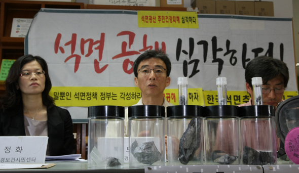백도명 환경보전시민센터 공동대표(가운데·서울대 보건대학원장)가 12일 오전 서울 종로구 누하동 환경운동연합에서 4대강 공사에 석면이 함유된 석재가 사용되고 있다고 밝히고 있다. 앞쪽에 놓인 것은 1급 발암물질 트레몰라이트 석면이 함유된 석재로 충북 제천시 수산면 일대의 4대강 공사 현장인 ‘한강 15공구 충주호 생태하천 조성사업’에 사용됐다.  이종근 기자 root2@hani.co.kr