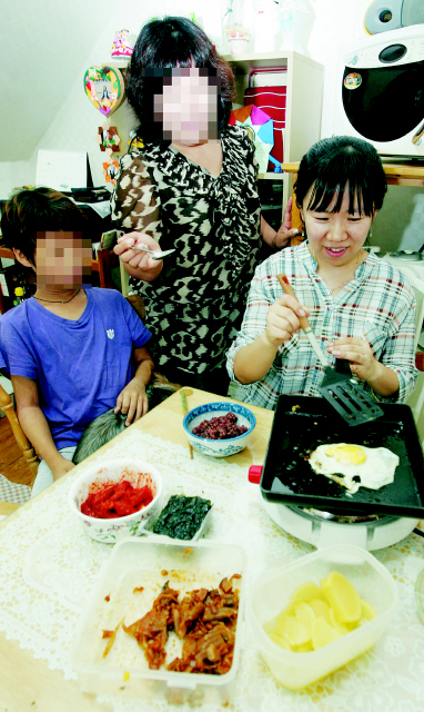 김소연 기자(오른쪽)가 서울 성북구 삼선동 장수마을의 최저생계비 체험 3인가구에서 박미영(가운데)씨 모자와 저녁을 만들고 있다. 이종찬 선임기자  <A href="mailto:rhee@hani.co.kr">rhee@hani.co.kr</A>