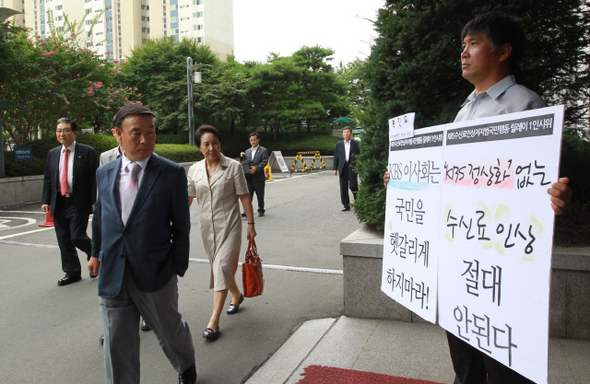  복진오 환경운동연합 영상팀 국장(오른쪽)이 24일 오후 서울 양천구 목동 방송회관 들머리에서 <한국방송>(KBS) 수신료인상저지 범국민행동 릴레이 1인 시위를 벌이자, 고영신(앞 왼쪽) 한국방송 이사 등이 손팻말의 글귀를 바라보고 있다. 이날 방송회관에서 이사회 주최의 네번째 ‘수신료 현실화’ 공청회가 열렸다. 이종근 기자 <A href="mailto:root2@hani.co.kr">root2@hani.co.kr</A>