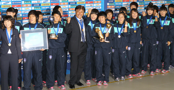 한국 축구 사상 처음으로 국제축구연맹(FIFA) 주관 대회 우승의 쾌거를 이룬 17살 이하 여자월드컵 한국 대표팀 선수들이 28일 오후 인천공항을 통해 금의환향했다. 우승트로피를 든 주장 김아름(앞줄 왼쪽 셋째)과 골든볼 및 골든부트 등 3관왕을 차지한 여민지(앞줄 왼쪽 여섯째) 등 선수들이 환영하는 시민들을 향해 밝게 웃고 있다. 김아름은 기자회견에서 “우리가 이렇게 성적을 냈을 때뿐만 아니라 항상 관심을 가져주셨으면 좋겠다”고 말했다. 인천공항/김진수 기자 <A href="mailto:jsk@hani.co.kr">jsk@hani.co.kr</A>