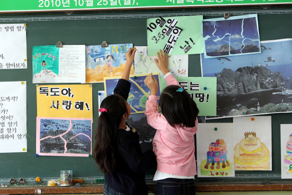 한국교원단체총연합회가 10월25일을 ‘독도의 날’로 지정·선포한 25일 오전, 서울 동작구 흑석초등학교 3학년 학생들이 ‘독도의 날’ 특별수업에서 직접 그린 독도 관련 포스터와 그림 등을 교실 칠판에 붙이고 있다. 한국교총은 고종이 110년 전 칙령 제41호를 제정해 독도의 영유권을 국제법적으로 확립한 것을 기념해 이날을 ‘독도의 날’로 지정했다.  김태형 기자 xogud555@hani.co.kr