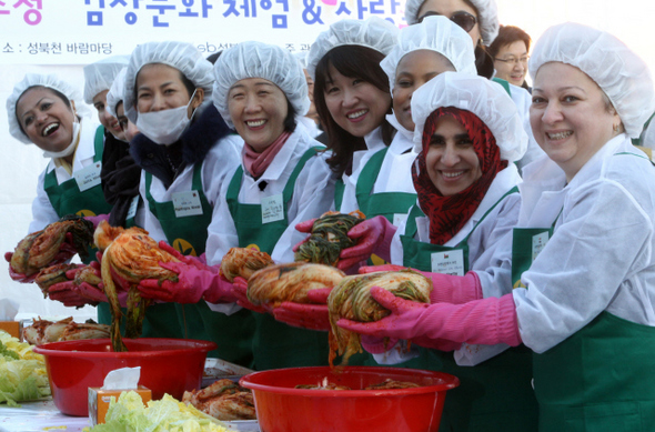 아바제 카사라이 주한이라크 대사 부인(맨오른쪽)과 아자 알하르티 주한 오만 대사 부인(오른쪽 둘째) 등 서울 성북구 성북동에 대사관저가 있는 주한 외국대사 부인들이 26일 오후 성북구청앞 성북천 바람마당에서 열린 ‘사랑의 김장문화체험행사’에서 자신들이 직접 담근 김치를 든 채 환하게 웃고 있다. 이 김치는 생활형편이 어려운 장애인 가정과 독거 노인, 다문화 가정 등에 전달될 예정이다.  강재훈 선임기자 khan@hani.co.kr