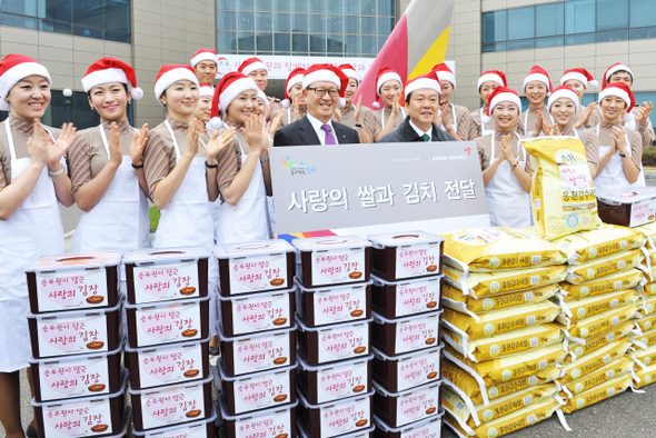 산타 차림을 한 아시아나항공 윤영두(가운데) 사장과 승무원들이 2일 서울 오쇠동 본사에서 노현송 강서구청장과 함께 ‘사랑의 쌀과 김치 전달식’을 하고 있다.