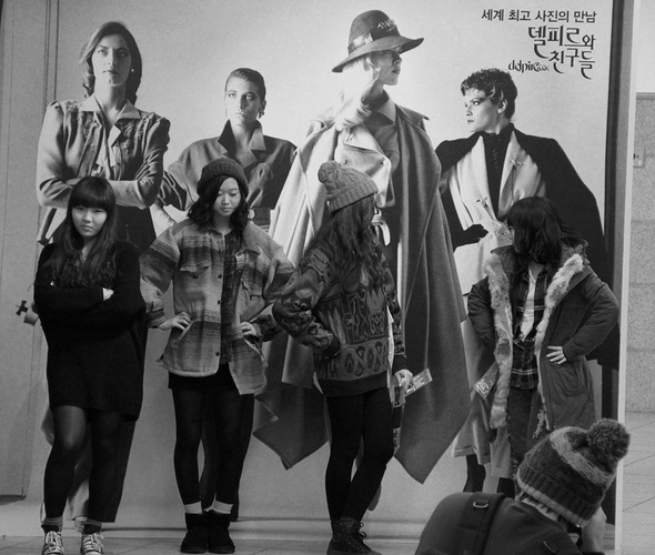 19. 젊은 관람객들이 포토존 앞에서 사진 속 모델과 같은 포즈를 취한 채 사진을 찍고 있다.