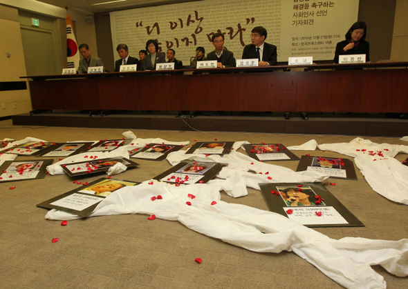 ‘삼성 직업병 문제 해결을 촉구하는 사회인사 선언’ 기자회견이 열린 21일 오전 서울 중구 태평로 한국언론회관에서 참석자들이 삼성반도체에서 일하다 백혈병 등으로 숨진 노동자들의 사진과 방진복을 앞에 둔 채 삼성과 정부가 적극적인 해결에 나설 것을 촉구하고 있다. 이날 발표된 선언에는 보건의료 전문가와 법조계, 학계, 노동계 등 사회인사 536명이 참여했다.  박종식 기자 anaki@hani.co.kr