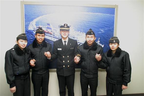 한국해양대 해사대학 김병주 사관장(가운데)이 캄보디아로 떠나는 촌 위차이(오른쪽에서 둘째) 등 캄보디아 유학생들과 손을 잡고 웃고 있다.  한국해양대 제공