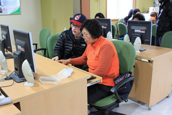 원광대 행정전산연구회 회원들이 전북 김제시 성덕면 남포리 마을 주민에게 컴퓨터 사용법을 가르치고 있다.  원광대 행정전산연구회 제공
