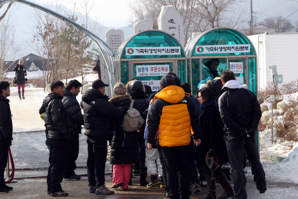 평창송어축제가 열린 강원도 평창군 진부면 오대천 인근 들머리에서 9일 오전 축제에 참가하려는 주민과 관광객들이 ‘방문객 무균소독실’ 앞에서 소독을 하기 위해 기다리고 있다. 이 축제는 애초 지난달 23일 열 예정이었으나, 개막을 하루 앞두고 평창군에서 구제역 양성 판정이 나오자 보름 남짓 미뤄졌다. 
 평창/김태형 기자 xogud555@hani.co.kr