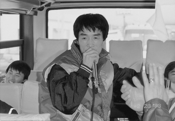 1993년께 어느 노동조합 행사에 참여한 고 배달호씨가 버스 안에서 마이크를 잡고 있다. “그는 동료들과 놀러 오면 항상 즐겁고 활기 있게 흥을 잘 돋우는 사람이었다”. 많은 사람들이 공장 안에서 자전거를 타고 다니며 여러 사람들을 만나고 호루라기를 불며 사람들을 모여들게 했던 그의 모습을 기억한다고 했다.  후마니타스 제공