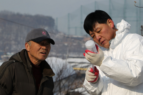 &raquo; 수의사 이흥열(오른쪽)씨가 주사기로 구제역 백신액을 뽑아내고 있다. 한겨레21 류우종 기자 