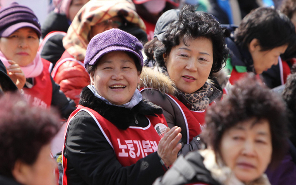 103번째 세계 여성의 날을 맞은 8일 여성노동자들은 꽃샘추위 속 찬바람에 몸을 내맡긴 채 길에 나앉았다. ‘노동자 평균임금의 절반 수준 임금’을 요구하며 이날 하루 파업을 벌인 고려대·연세대·이화여대 청소노동자들이 이날 오후 서울 신촌동 연세대 본관 앞에서 밝은 표정으로 풍물패의 공연을 보고 있다. 세계 여성의 날은 1908년 수천명의 미국 봉제산업 여성노동자들이 미성년자 노동 금지와 여성 참정권 등을 요구하며 시위를 벌인 것을 기념하는 날이다.  이종근 기자 root2@hani.co.kr