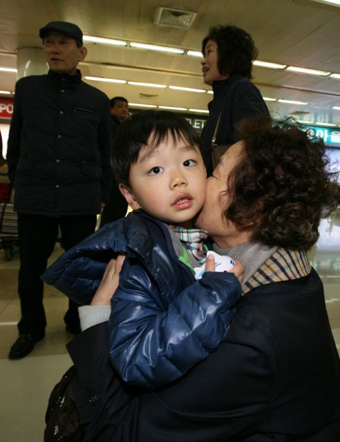 <b>무서웠지?</b> 13일 오전 서울 강서구 공항동 김포공항 국제선 입국장에서 한 할머니가 일본 동부지역 대지진 때문에 귀국한 손자를 껴안은 채 뺨에 입을 맞추고 있다.  이종근 기자 root2@hani.co.kr