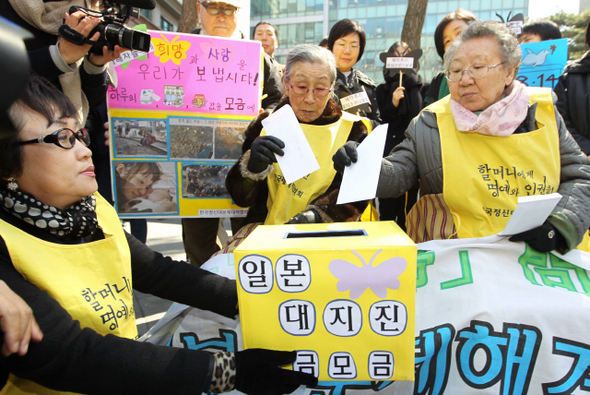 일본이 상처줬지만…   일본군 위안부 피해자인 길원옥(84·앞줄 오른쪽부터), 김복동(86) 할머니가 23일 낮 서울 종로구 중학동 주한 일본대사관 앞에서 열린 ‘일본군 위안부 문제 해결을 위한 정기 수요집회’에서 일본 지진 피해자들을 돕기 위해 피해자 할머니들이 함께 준비한 성금을 모금함에 넣고 있다. 한국정신대문제대책협의회는 지진으로 고통을 겪고 있는 일본인들을 돕자는 할머니들의 제안에 따라 이날부터 모금 전용계좌(신한은행 100-019-906649, 예금주 정대협)를 열고, 다음달 26일까지 5주간 모금하기로 했다.  이종찬 선임기자 rhee@hani.co.kr
