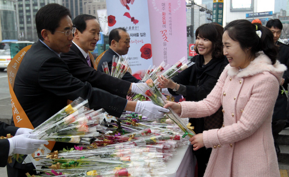 농협 임직원들이 29일 오전 서울 광화문 네거리에서 일본 대지진으로 인한 수출부진으로 어려움을 겪고 있는 화훼 농가들을 돕기 위한 ‘수출화훼 팔아주기’ 캠페인을 벌이면서 출근하는 시민들에게 꽃을 나눠주고 있다.  박종식 기자 anaki@hani.co.kr