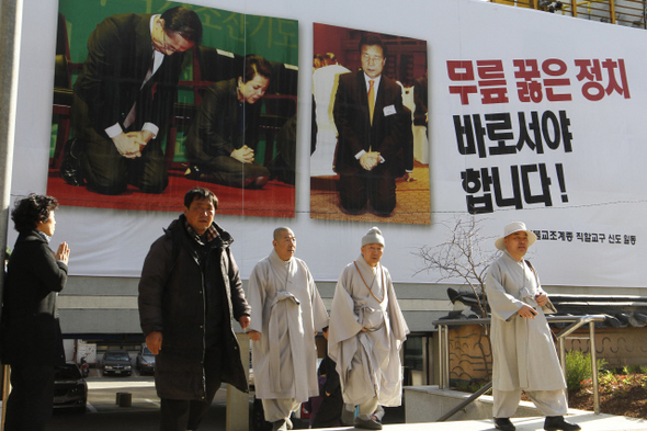 부처님 오신날을 한달여 앞둔 11일 오후 서울 견지동 조계사 경내에 지난달 3일 서울 코엑스에서 열린 국가조찬기도회에서 이명박 대통령 부부와 손학규 민주당 대표가 무릎을 꿇은 채 기도하는 사진을 담은 사진 펼침막이 걸려있다. 조계사 쪽은 “정치인들의 기독교 편향에 대한 비판의 뜻을 담아 대한불교조계종 직할교구 신도들이 만들어 단 것”이라고 밝혔다.  김정효 기자 hyopd@hani.co.kr