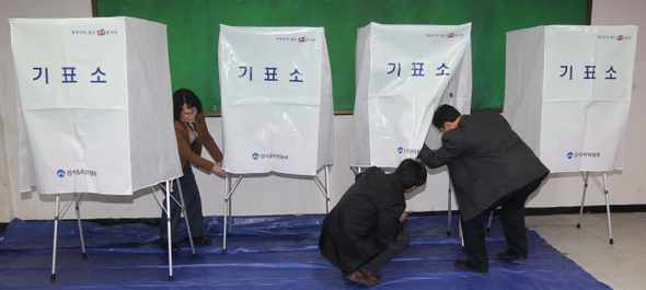경기도선거관리위원회 직원들이 26일 오후 경기 성남시 분당구 분당동 장안중학교에 기표소를 설치하고 있다.  성남/박종식 기자 anaki@hani.co.kr
