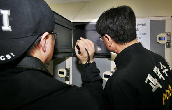 서울지방경찰청 과학수사대원들이 12일 오후 폭발 사고가 난 서울 중구 서울역 2층 물품보관함에서 문을 연 뒤 불빛을 비춰 내부를 살펴보고 있다. 이종근 기자 root2@hani.co.kr