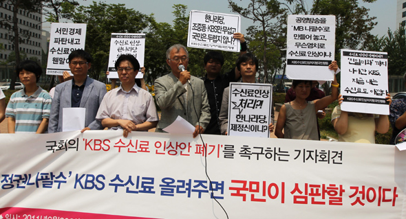 KBS수신료인상저지범국민행동 주최로 20일 정오 서울 여의도 국회 앞에서 열린 기자회견에서 박우정 민주언론시민연합 이사장(가운데 마이크 든 이)을 비롯한 참석자들이 한국방송(KBS) 수신료 인상안 폐기를 촉구하고 있다. 류우종 기자 <A href="mailto:wjryu@hani.co.kr">wjryu@hani.co.kr</A>