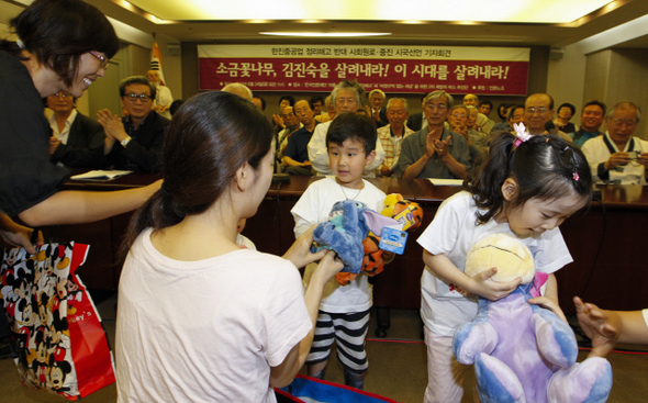 ‘비정규직 없는 세상 만들기’ 회원들이 24일 오전 서울 태평로 한국언론회관에서 열린 ‘정리해고와 비정규직 없는 세상을 위한 사회원로·중진 시국선언 기자회견’에 엄마와 함께 참석한 한진중공업 해고 노동자의 아이들에게 인형을 선물하고 있다.  김정효 기자 hyopd@hani.co.kr