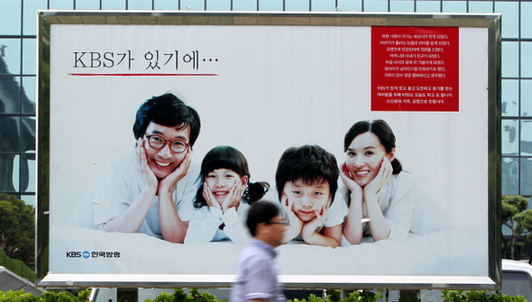1일 오후 서울 여의도 <한국방송>(KBS) 본관 앞의 수신료 인상 홍보 간판 앞으로 한 시민이 지나고 있다.  박종식 기자 anaki@hani.co.kr