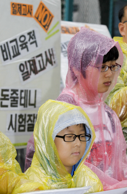 일제고사 싫어요 국가수준학업성취도평가(일제고사)가 실시된 12일 오전 서울 세종로 정부중앙청사 후문 앞에서 일제고사반대 시민모임과 평등교육실현을 위한 전국학부모회가 연 기자회견에 ‘일제고사’를 보지 않고 교사인 어머니와 함께 참석한 중3 학생(오른쪽)과 한 초등 3년 어린이가 일제고사 규탄발언을 듣고 있다.  김정효 기자 hyopd@hani.co.kr