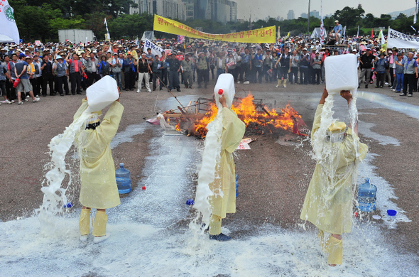 상복을 입은 한국낙농육우협회 회원들이 26일 오후 서울 여의도공원 문화마당에서 ‘전국 낙농 육우인 총궐기대회’를 열어 ‘목장 원유가 현실화’를 요구하며 우유를 몸에 쏟아붓고 있다. 신소영 기자 viator@hani.co.kr