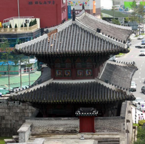보물 1호인 흥인지문(동대문)의 지붕 일부가 지난 29일 폭우로 훼손돼 2일 오후 마루 속에 있던 진흙이 드라나 있다. 종로구청은 날이 갠 이날 오후 보수공사를 벌였다. 신소영 기자 viator@hani.co.kr