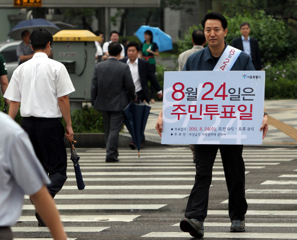 오세훈 서울시장이 17일 오전 서울 중구 을지로입구역 근처 횡단보도에서 무상급식 관련 주민투표에 참가할 것을 권유하는 내용의 대형 손팻말을 들고 캠페인을 벌이고 있다.  김태형 기자 xogud555@hani,.co.kr