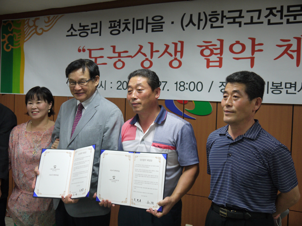 지난 27일 전북 완주군 비봉면사무소에서 열린 평치마을과 한국고전문화연구원의 교류 협약식에서 조광 한국고전문화연구원 원장(왼쪽 두번째)과 조한용 평치마을 개발위원장(왼쪽 세번째)이 협약서를 펼쳐보이고 있다. 완주/박임근 기자 pik007@hani.co.kr 　