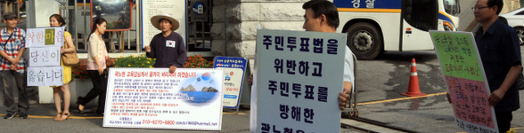 곽노현 서울시교육감을 지지하는 네티즌(손팻말 왼쪽 첫째 둘째)과 구속수사를 촉구하는 시민들이 29일 오전 서울 종로구 신문로 서울시교육청 앞에서 각자의 의견을 적은 손팻말을 들고 서 있다.  김태형 기자 xogud555@hani.co.kr
