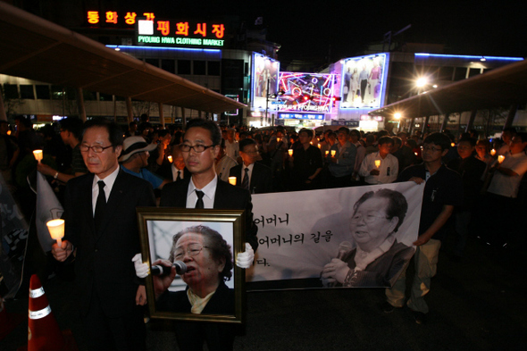 ‘그의 삶’ 평화시장 뒤로하고 고 이소선씨의 영정을 든 박계현 전태일재단 사무총장과 권영길 민주노동당 원내대표(앞줄 왼쪽) 등 추모객들이 5일 저녁 ‘어머니의 길 걷기’ 행사가 열린 서울 청계천 전태일 다리에서 손에 촛불을 들고 걸으며 고인을 기리고 있다.   이종근 기자 root2@hani.co.kr
