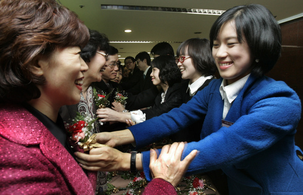 &raquo; 현대건설 여성 신입사원들이 서울 종로구 현대건설 본관 대강당에서 열린 신입사원 입사식에서 부모님께 감사하는 마음으로 카네이션을 달아주고 있다. 한겨레 김진수
