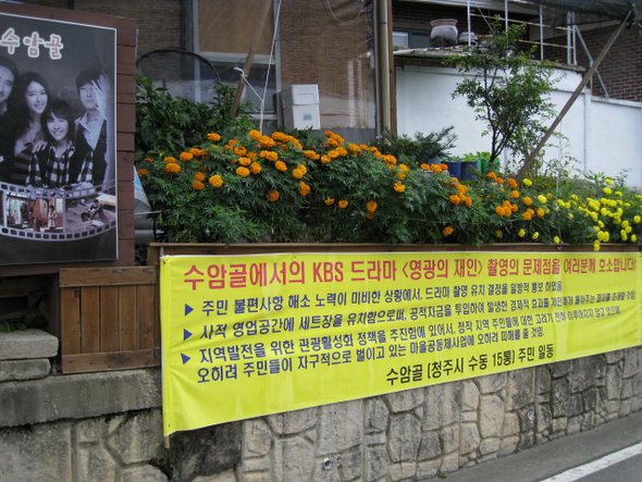 ‘김탁구 마을’로 이름난 충북 청주시 수동 수암골에서 드라마 <영광의 재인>이 다시 제작되고 있지만, 주민들이 마을 곳곳에 펼침막을 내걸고 드라마 제작에 반대하고 있다.
