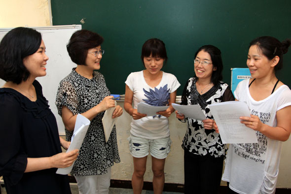 지난 5일 서울 송파구 마천동 송파다문화센터에서 중학교 입학자격 검정고시를 준비하는 전향화(29·가운데)씨 등 중국인 학생들과 전직 영어교사인 정연순(49·왼쪽 두번째)씨가 수업을 하며 활짝 웃고 있다. 서울 송파구 제공