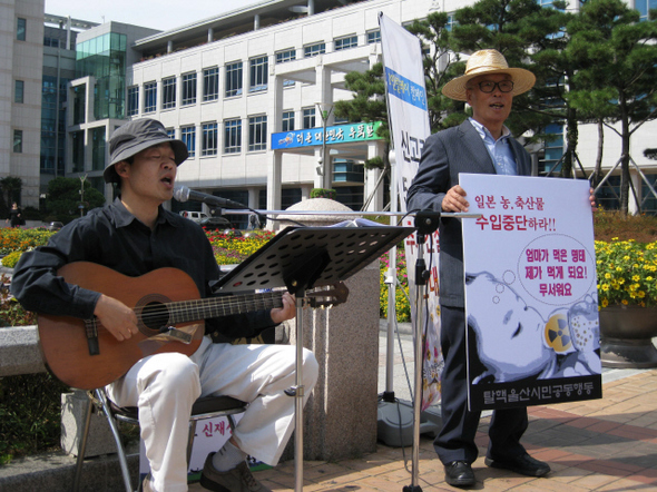 경주환경운동연합 의장인 김익중 동국대 교수(왼쪽)가 6일 낮 12시 울산시청 앞에서 한국수력원자력의 신고리원전 5·6호기 추가 건설에 반대해 거리공연을 하며 1인시위를 벌였다. 김 교수는 이날 장태원 울산환경운동연합 공동의장(오른쪽) 등과 함께 1인시위에 참가해 1시간 동안 기타 반주를 하며 ‘아침이슬’과 ‘광야에서’ 등의 노래를 불러 눈길을 끌었다.  신동명 기자 <A href="mailto:tms13@hani.co.kr">tms13@hani.co.kr</A>