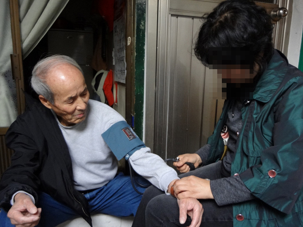 24일 서울시 구로구 보건소 방문간호사 최아무개씨가 구로동 김재정 할아버지의 집을 방문해 혈압을 재고 있다.  최우리 기자